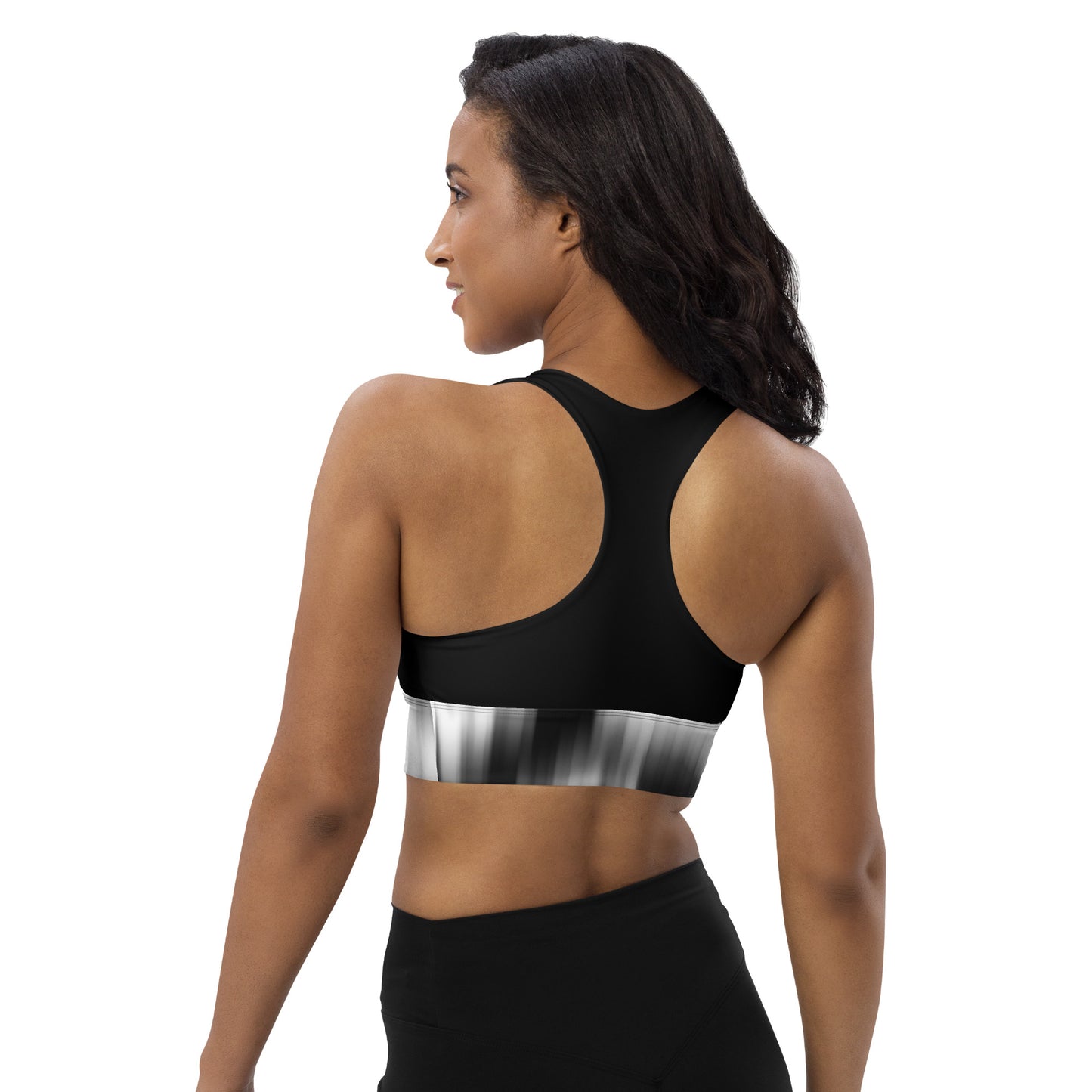 Back view of a woman wearing the Hellbeing recycled sports bra in black and grayscale