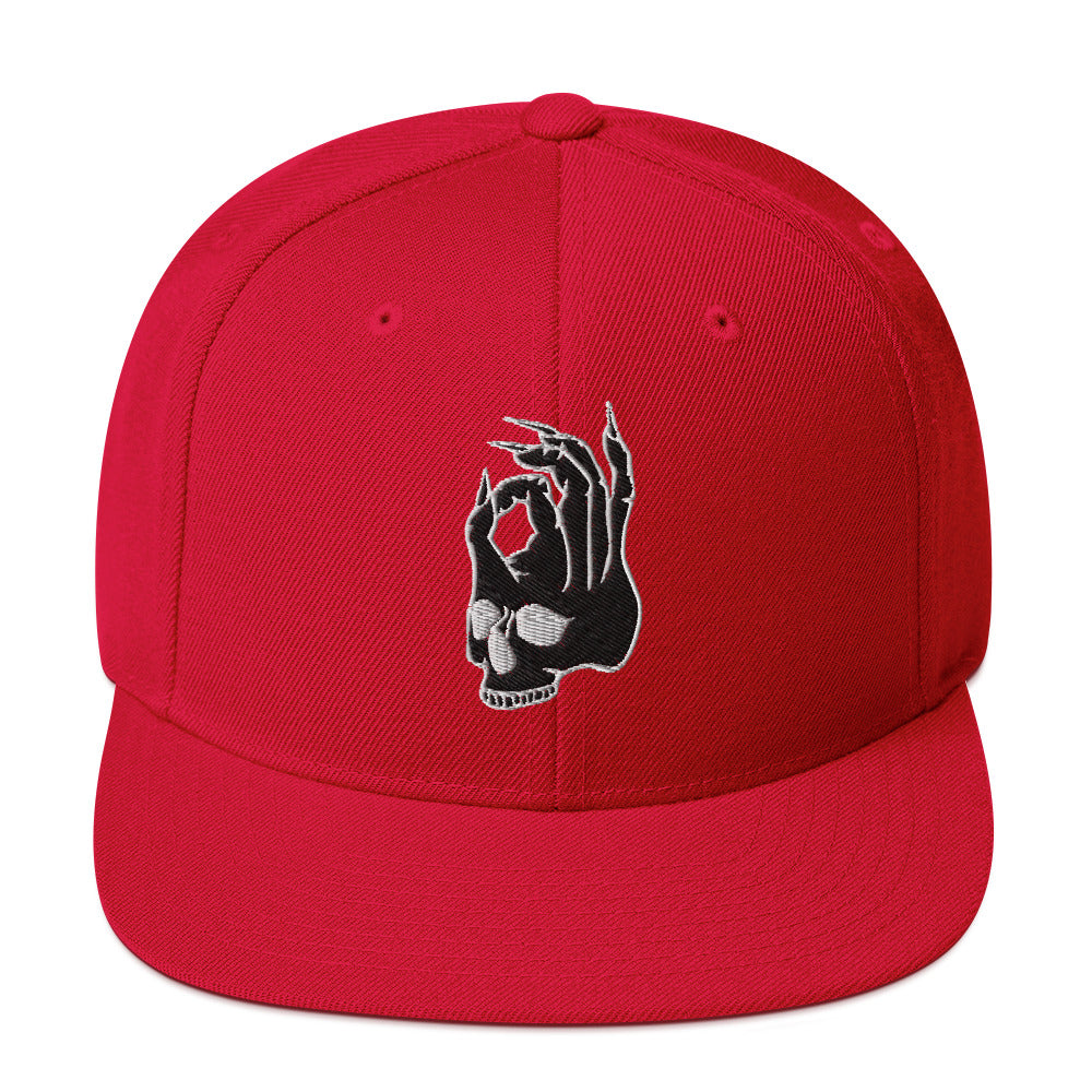 Front view of the Hellbeing skull embroidered 5 panel red trucker hat