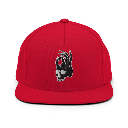 Front view of the Hellbeing skull embroidered 5 panel red trucker hat