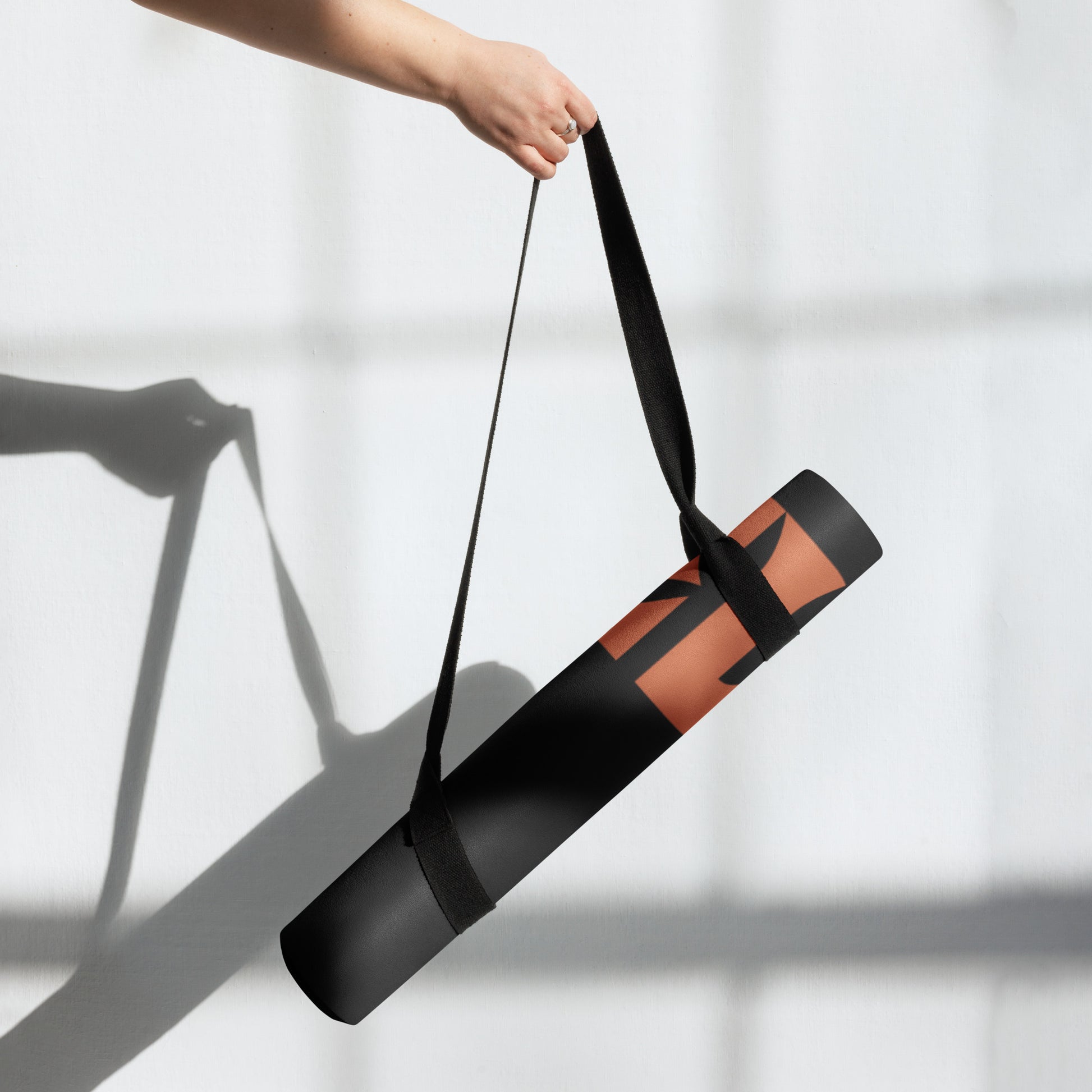 Rolled up view of the Hellbeing black and red logo, Rubber, anti-slip Yoga mat with a microsuede top.